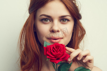 美丽的红发女人玫瑰花朵特写魅力