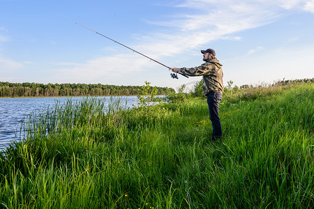 钓鱼摄影照片_河上的人抛出一个旋转的钓鱼