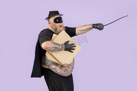 紫色背景中，身着 Zorro 服装、带披萨盒的好斗胖子