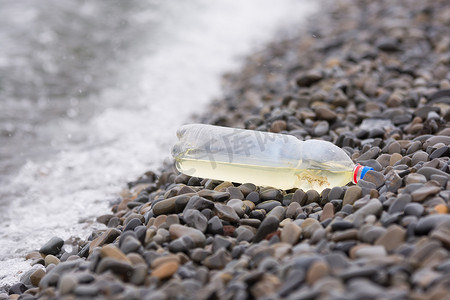 躺在卵石海岸上的塑料瓶