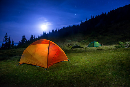 两个发光的橙色和绿色露营帐篷