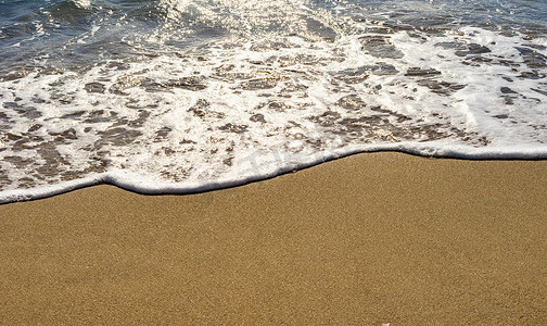 金色沙滩背景上的波浪
