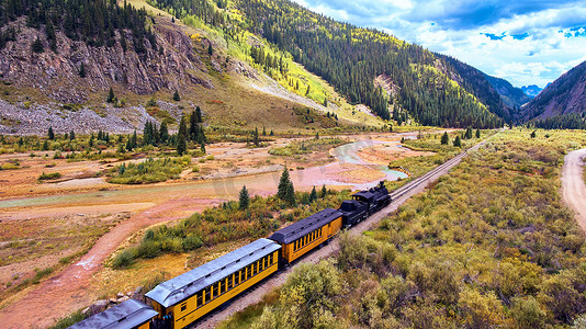 有煤的老黑火车穿过群山环绕的山谷