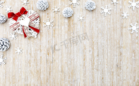 平躺着破旧的圣诞复制空间，在浅色木质背景下，左上角有白色木质雪花、白色松果和白色木质装饰心