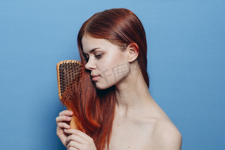 梳头发的人摄影照片_漂亮女人梳头裸肩护发