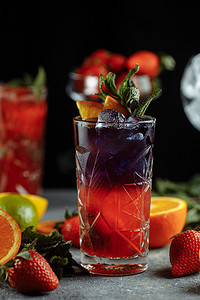 夏季色彩缤纷的清凉饮料，冷草莓柠檬汁，玻璃杯里加冰块，饰有切片新鲜柠檬