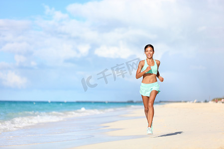 跑步亚洲女摄影照片_旅游度假期间在沙滩上跑步的快乐健身女跑步者