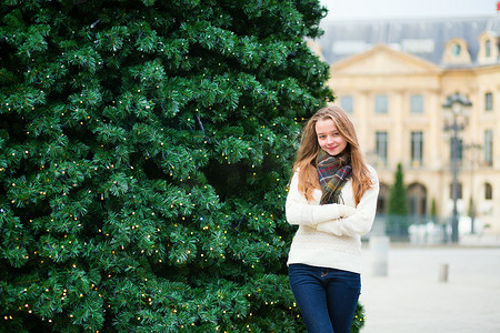 巴黎街道摄影照片_在为圣诞节装饰的巴黎街道上的女孩