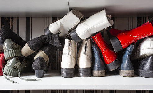 在鞋架中收集旧的不同鞋子以供存放、杂乱和需要整理、带架子的衣柜在室内设计中