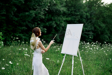 穿白裙的女人在户外爱好创意上画画