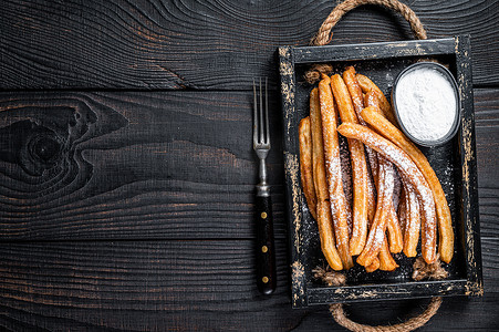 Churros 油炸棒用木托盘中的糖粉。