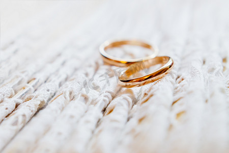 一对金色结婚戒指在蕾丝面料上。