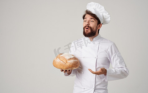 厨师手里拿着一条面包，背景浅，专业服装裁剪