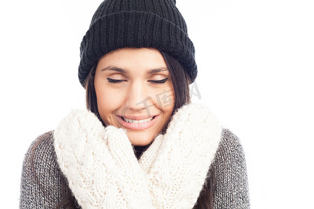 下雪感冒摄影照片_漂亮的黑发女人，戴着羊毛帽，毛衣和感冒手套