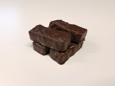 白黑巧克力摄影照片_白色表面上的黑巧克力糖块