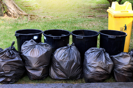 废物、黑袋和垃圾箱中的垃圾、花园公园里许多垃圾箱垃圾、垃圾污垢和垃圾袋、塑料垃圾