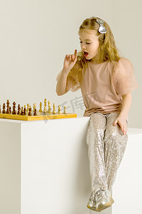 智能造摄影照片_下棋的小女孩。孩子的创造性教育。