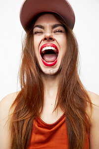 闭着嘴巴摄影照片_一个戴着帽子的女人的肖像有趣的嘴巴张开闭上眼睛红唇