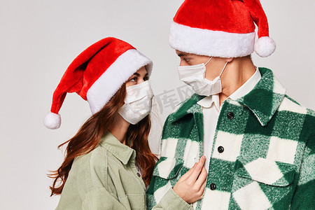 可爱的年轻夫妇圣诞帽医用面具特写拥抱