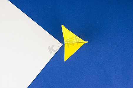 白色和蓝色纸背景上带纸飞机的旅行概念
