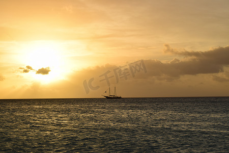 日落真实摄影照片_阿鲁巴白色海滩上美丽的金色日落，碧绿的海水 — 加勒比日落 — 真实的色彩，无滤镜