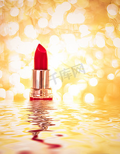 金色背景广告摄影照片_金色背景上的红色唇膏、化妆和化妆品