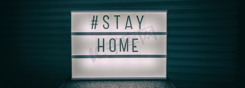 COVID-19横幅冠状病毒呆在家里灯箱消息标志，带有文本标签“STAYHOME”在灯光下发光，以促进自我隔离呆在家里标题背景