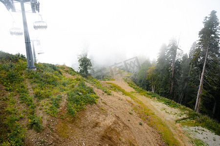 淡季摄影照片_淡季雾天滑雪胜地的缆车
