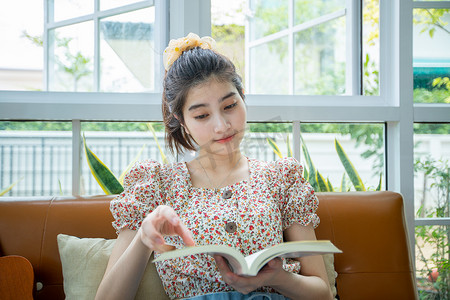 亚洲女性在家里的花园里悠闲地读书