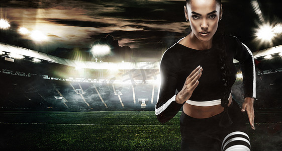 运动健身海报摄影照片_一个强壮的运动员，女子短跑运动员，穿着运动服、健身和运动动机在 staidum 上跑步。