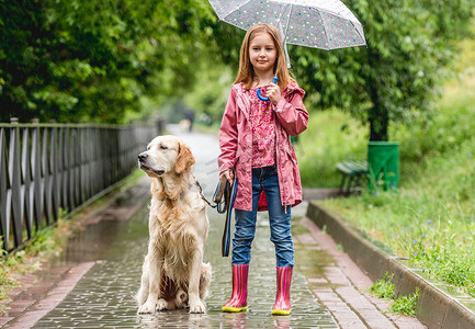 小女孩在雨天公园遛狗