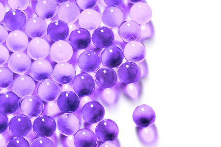 胶囊紫色摄影照片_白色背景上具有选择性聚焦的质子紫色球形胶囊