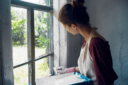 有刷子油漆窗口的妇女家庭装修内部