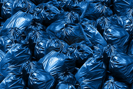 黑色垃圾塑料袋摄影照片_垃圾袋背景堆，蓝色容器，垃圾，垃圾，垃圾，塑料袋堆