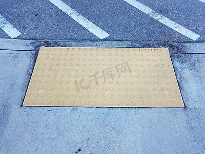 颠簸摄影照片_水泥人行道或地面上的黄色触觉颠簸