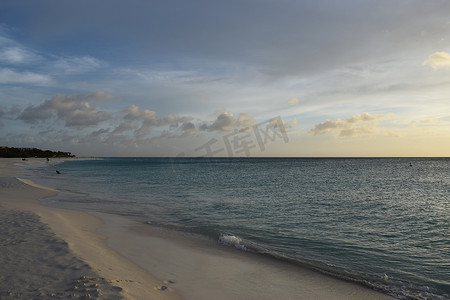 日落真实摄影照片_阿鲁巴白色海滩上美丽的金色日落，碧绿的海水 — 加勒比日落 — 真实的色彩，无滤镜