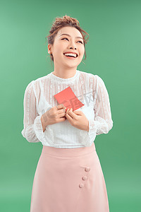 快乐的年轻美丽亚洲女孩，带着绿色背景的爱情明信片情人节