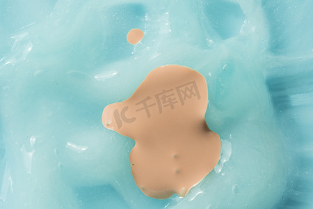 粉底液涂在蓝色奶油纹理背景上。