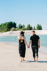 一对年轻夫妇，一个男人和一个穿黑衣服的女孩正在 t 上行走