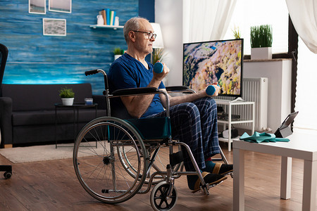 坐轮椅的老人在平板电脑上观看在线锻炼视频