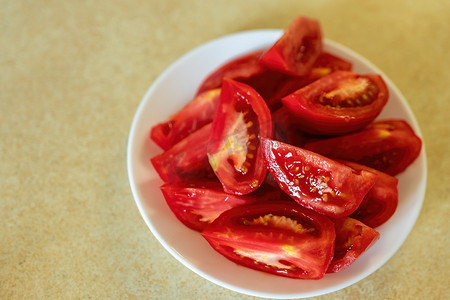 白枝条摄影照片_新鲜切好的西红柿放在白盘上。