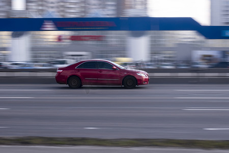 丰田汽车摄影照片_乌克兰，基辅- 2021年3月21日：红色丰田凯美瑞汽车在街上行驶。