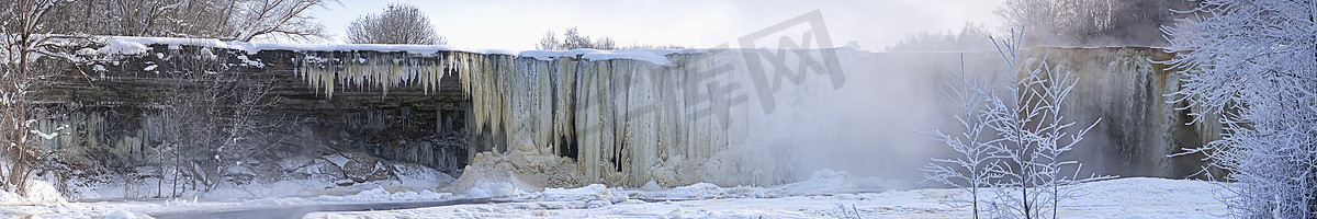 贾冰摄影照片_冬季日出灯下冰冻美丽的贾加拉瀑布，河中的倒影。