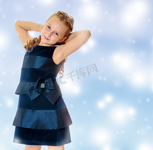 蓝色的裙子摄影照片_美丽的小女孩穿着一件蓝色的裙子。