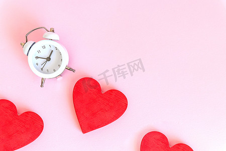 爱的时间-闹钟和粉红色背景的心。与时钟的爱心。