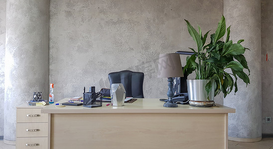 办公室工作场所的设计，在灰色的墙壁背景上配备现代设备和便利设施。