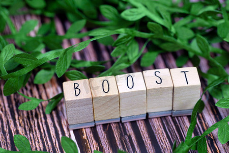 Boost text wooden cubes immune system text with wood cubes and fresh organic leafs on background with wood texture, Boost for Healht 概念