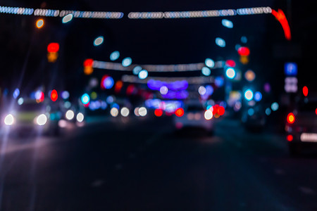 夜间街道汽车交通的离焦图片-从道路上看。