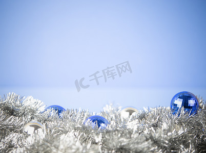 圣诞复制空间，蓝色和银色明亮的小玩意，银色装饰链花环，浅蓝色背景，散景效果