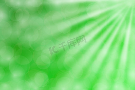 金色渐变的背景摄影照片_彩色绿色散景灯光束照射在渐变绿色背景上用于复制空间，散景彩色浅绿色柔和的阴影，散景灯照射在渐变柔和的绿色上